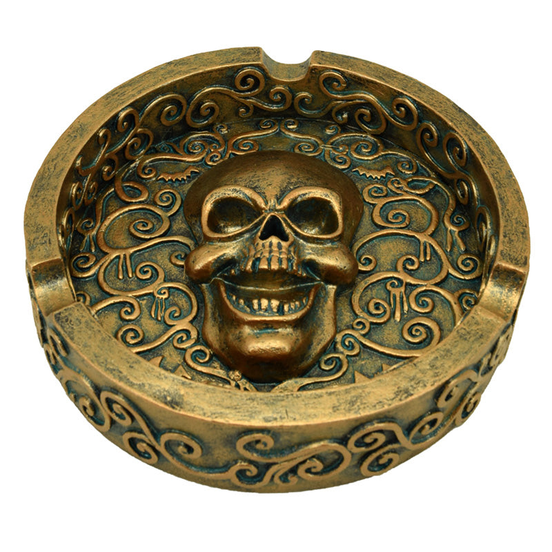 Decorative ashtray featuring a metallic brushed gold skull design