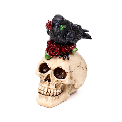 Raven on decorative skull with red roses