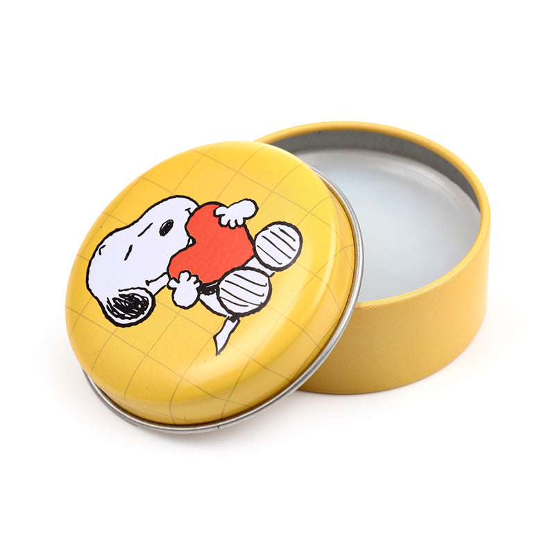 Peanuts Lip Balm tin displayed with decorative ornaments