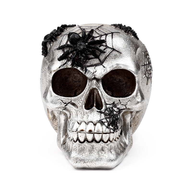 Close-up of silver skull ornament with spider web details