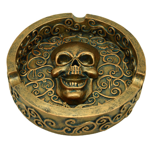 Decorative ashtray featuring a metallic brushed gold skull design
