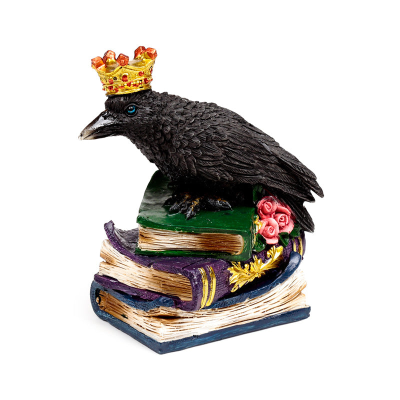 Side view of crow ornament on a stack of books