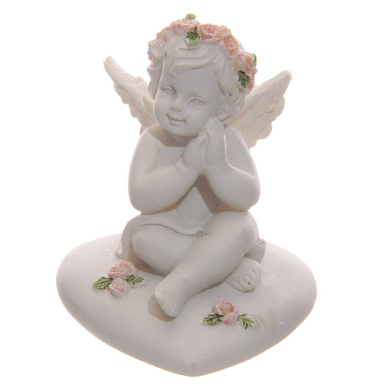 Close-up of Collectable Cherub Sitting on Heart with Pink Roses